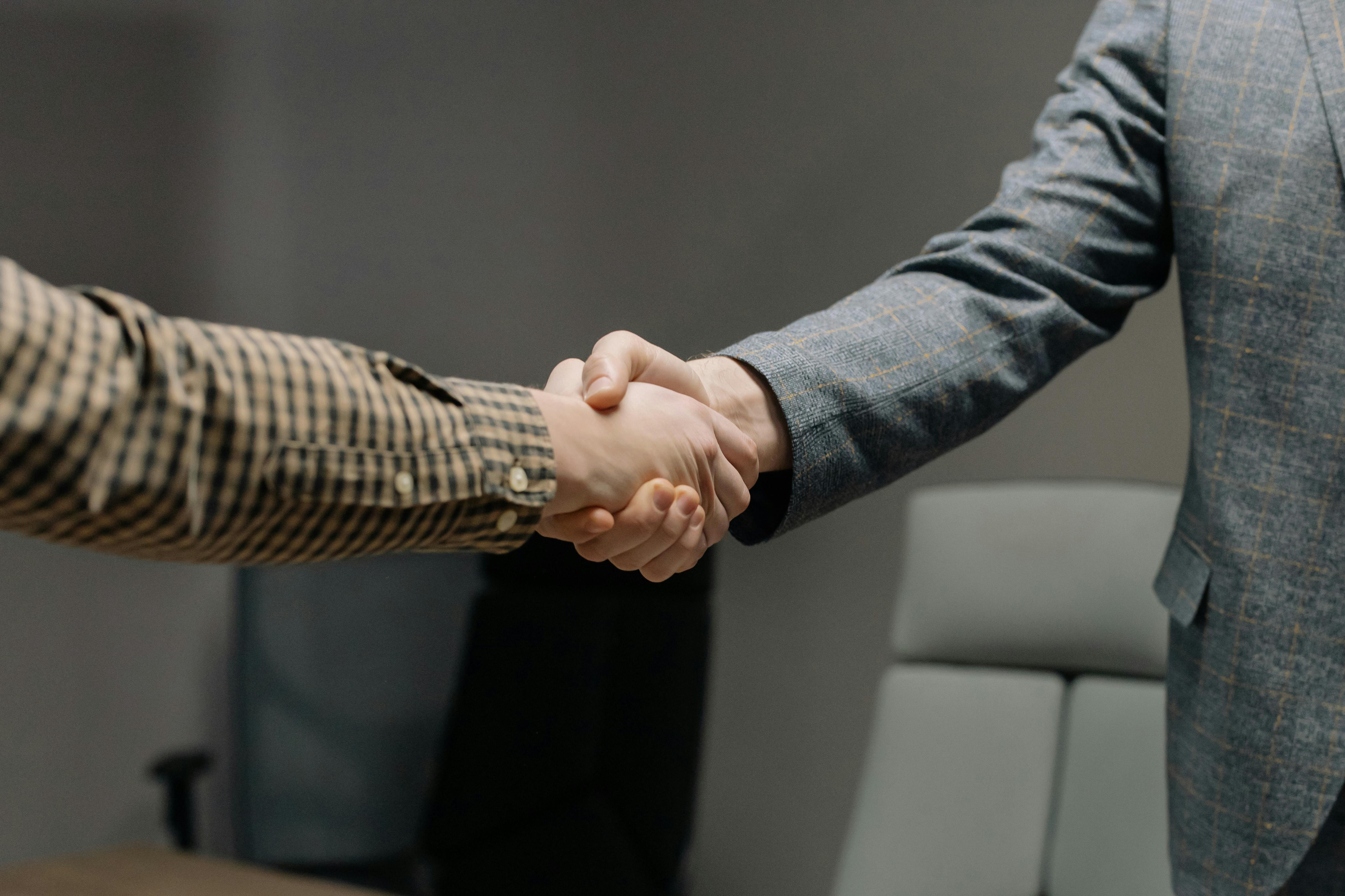 Community leaders sharing a handshake across a meeting table